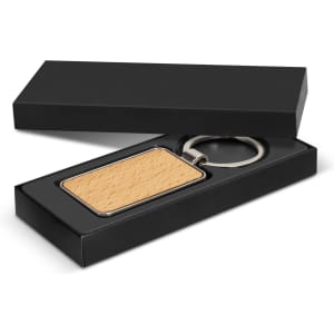 A rectangular key ring with a wooden surface, presented in a black gift box.