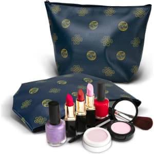 A navy cosmetic bag with a gold pattern, accompanied by various makeup products including lipsticks, nail polish, and compact.