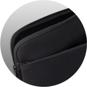 A large black laptop sleeve with a zippered opening and a smooth surface, featuring one visible internal pocket.