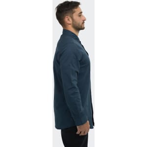 A side view of a man wearing a dark blue TRENDSWEAR button-up poplin shirt. The shirt has a collar and long sleeves.