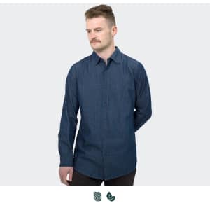 A man wearing a dark blue button-up denim shirt, featuring long sleeves and a fitted design.