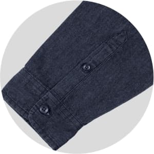 A navy denim button-up shirt featuring a buttoned cuff and a subtle texture, complete with a logo.