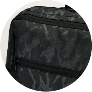 A black and grey camouflage backpack featuring a zippered pocket and a textured fabric design.