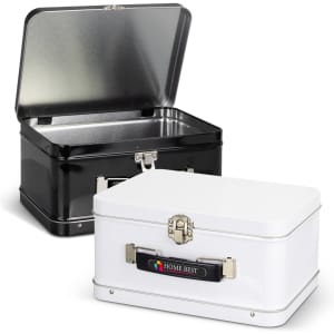 Two tin lunch boxes, one black and one white, with shiny interiors and metal latches, featuring a logo on the white box.