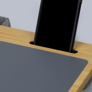 A bamboo lap desk featuring a grey surface and a slot for holding a smartphone.