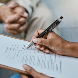 A metal pen with a textured dark blue grip and a silver detailing at the end.