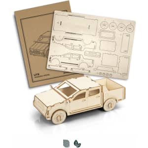 A wooden model of a UTE in a light natural finish, accompanied by a sheet of wooden parts for assembly.