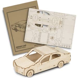 A wooden model of a sedan car with laser-cut pieces displayed alongside its packaging. The model features a natural wood finish.