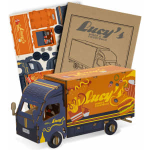 A small wooden model of a truck in blue and orange, with accompanying cardboard pieces for assembly.