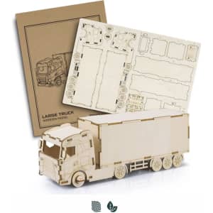 A wooden model of a large truck in natural finish, with assembly instructions displayed beside it.