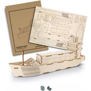 A wooden model of a cargo ship in natural colour, accompanied by assembly sheets. The packaging features a logo.