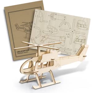A wooden helicopter model in light brown, accompanied by assembly instructions on a sheet of wood.