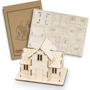 A wooden model of a house in light beige, accompanied by a flat pack of laser-cut pieces and packaging.