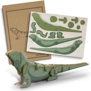 A wooden model of a tuatara in green and brown, with layered pieces and a backing card featuring an illustration.