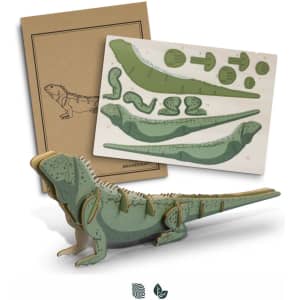 A green wooden tuatara model with assembly instructions, displayed alongside a kraft paper packaging. It features intricate details.