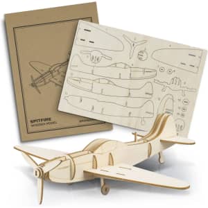 A wooden Spitfire model kit, with unfinished light wood components and a detailed instruction sheet in a brown cover.