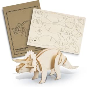 A wooden model of a triceratops in natural wood colour, with a template sheet and design outline behind it.