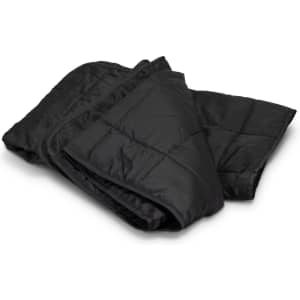 A black puffer blanket is neatly folded, showcasing its quilted texture and warm design. It has a branding logo.
