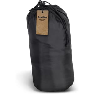 A black puffer blanket stored in a compact roll, with a drawstring closure and a tag attached.