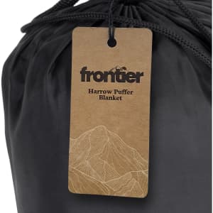 A black puffer blanket with a tag featuring a logo and mountain design.