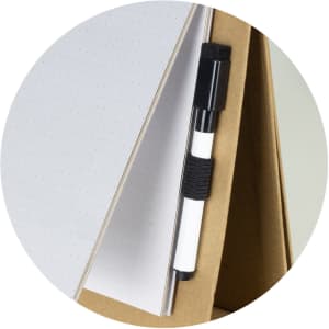 A whiteboard notebook in a triangular shape with dot grid pages and a black pen attached. Includes a simple logo.