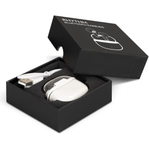 A black box containing white Rhythm Bluetooth earbuds and a USB charging cable. The headset is neatly housed inside the box.
