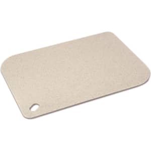 A light beige chopping board with a rounded corner and a hole for hanging. It features a smooth, speckled surface and has a logo.
