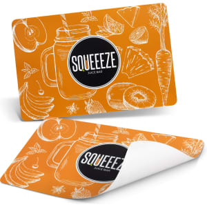 An orange place mat featuring hand-drawn fruits and vegetables with a logo.