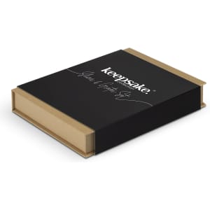 A black box with a gold base, featuring the Keepsake logo, containing kitchen slicer and grater utensils.