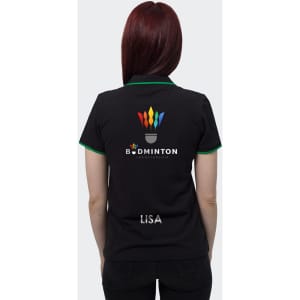A black women's polo shirt with green accents, featuring a logo on the back and a name on the lower hem.