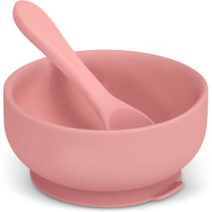 A pink suction bowl set for kids, including a matching spoon, designed for stable use on surfaces.