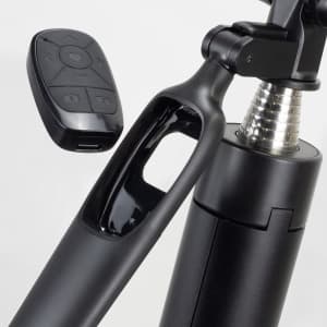 A black selfie stick tripod with a remote control attached, featuring a shiny metallic section and a sleek design.