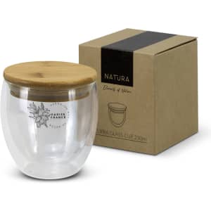 A drink cup made of clear glass with a bamboo lid, accompanied by a brown kraft box, features a logo.