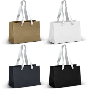 A set of four small ribbon handle paper bags in gold, white, navy, and black. Each bag has matching ribbon handles.