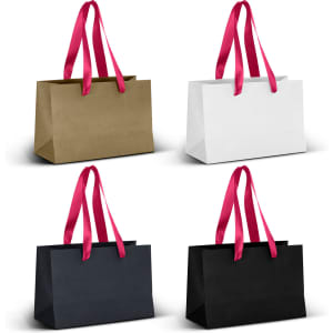 A series of four small ribbon handle paper bags in gold, white, navy, and black with pink handles.