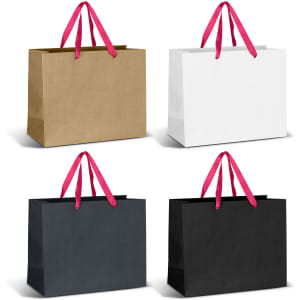 Four large paper bags with pink ribbon handles, featuring brown, white, and two black options. Each bag has a logo.