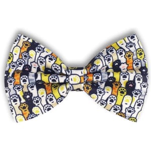 A bow tie featuring a pattern of colourful ghosts on a white background with black accents. The product has a logo.