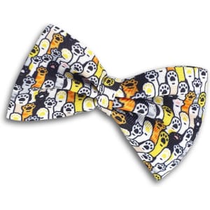 A pet bow tie featuring a pattern of colourful dogs and paw prints on a black background.