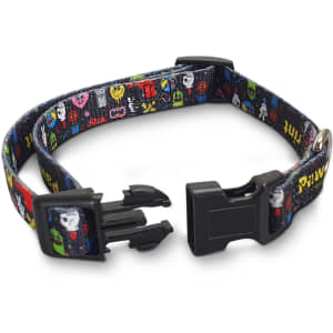 A black dog collar with a vibrant, multi-coloured pattern featuring various cartoonish designs and a plastic buckle.