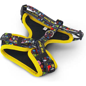 A pet harness in multicoloured patterns with a black mesh design and yellow trim. It features adjustable straps and a branding logo.