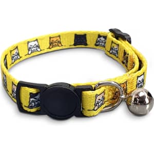 A yellow cat collar featuring a playful pattern of cartoon cats and a silver bell. Includes a branding logo.