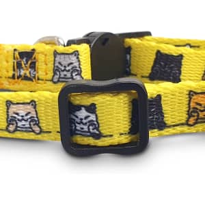 A yellow cat collar featuring various cartoon cats in shades of grey, black, and orange with a black buckle.