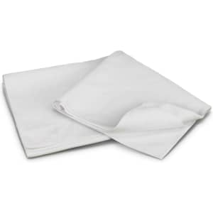 A white beach towel folded and slightly unfurled, with soft texture and a simple design. It has a logo.