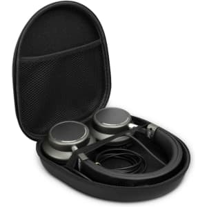 A set of green wireless headphones placed inside a black protective case with a mesh pocket for accessories.