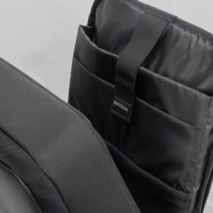 A black anti-theft backpack briefcase with multiple internal compartments and a logo tag.