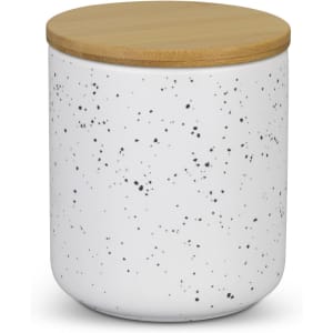 A white speckled candle jar with a bamboo lid, designed for home decor.