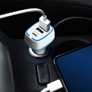 A USB car charger in white and blue plugged into a vehicle's power socket, with a charging cable connected to a phone.