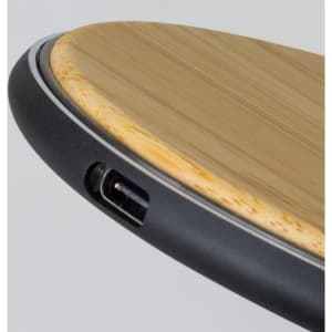 A bamboo wireless fast charger featuring a sleek black edge and a USB port.