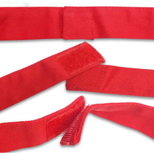 A bright red apron with velcro fastenings is displayed, showcasing its fabric texture and design.