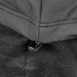 A close-up of the zippered neckline on a black soft shell jacket, featuring a pull tab and stitched detailing.